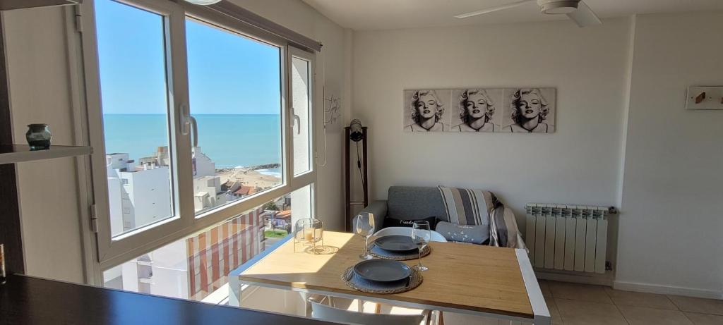 a dining room with a table and a large window at La Perla I in Mar del Plata