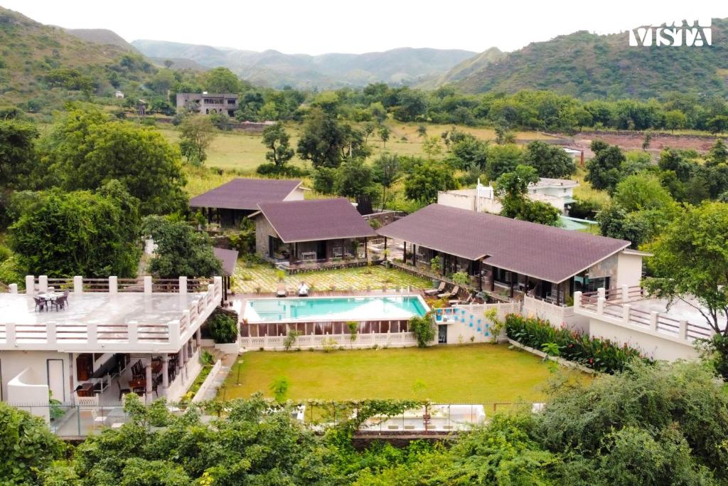 une vue aérienne d'une maison avec piscine dans l'établissement StayVista at The Earthen Boutique with Spacious Pool, Terrace, Lawn & Games, à Udaipur