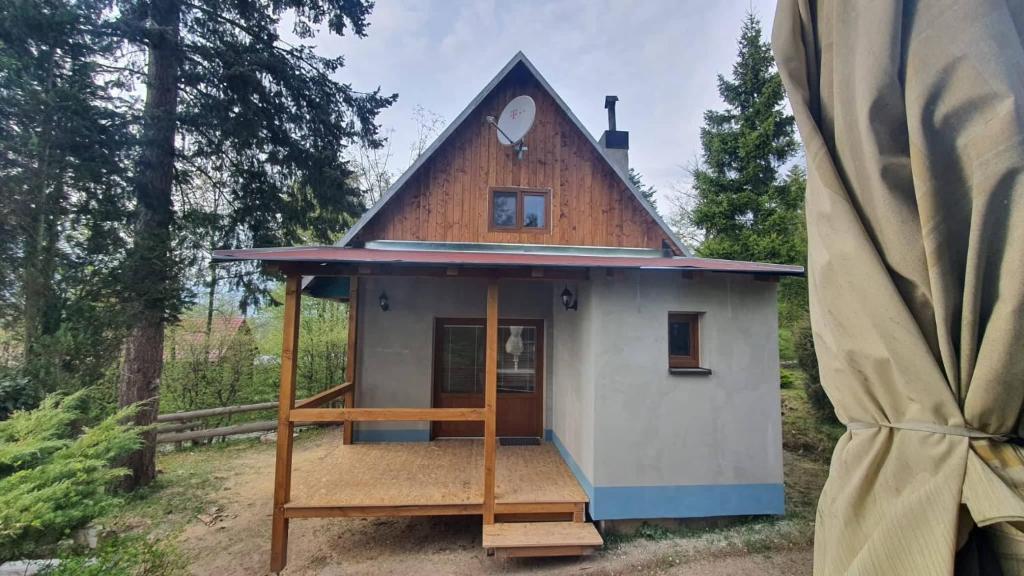 una casa pequeña con techo de gambrel en Chata v Jedovnicích u rybníka Olšovec, en Jedovnice