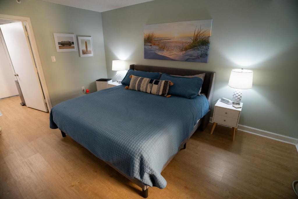 a bedroom with a bed with a blue comforter at Sunny Seaside Escape Perfect for Couples in Myrtle Beach