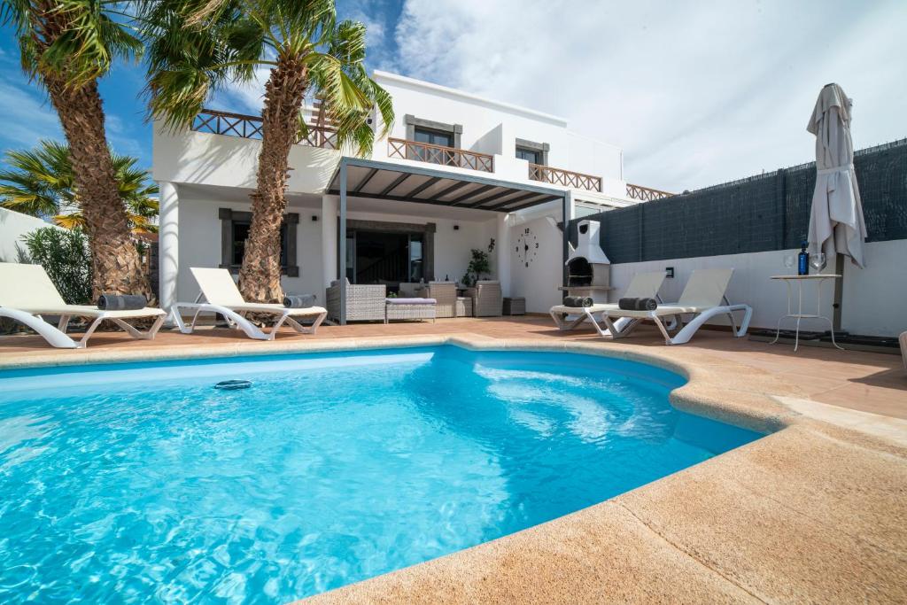 a swimming pool in front of a villa at Villa Ariana Playa Blanca in Playa Blanca