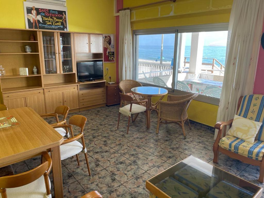 a living room with a table and chairs and a view of the ocean at Broadway es Mar in El Perelló