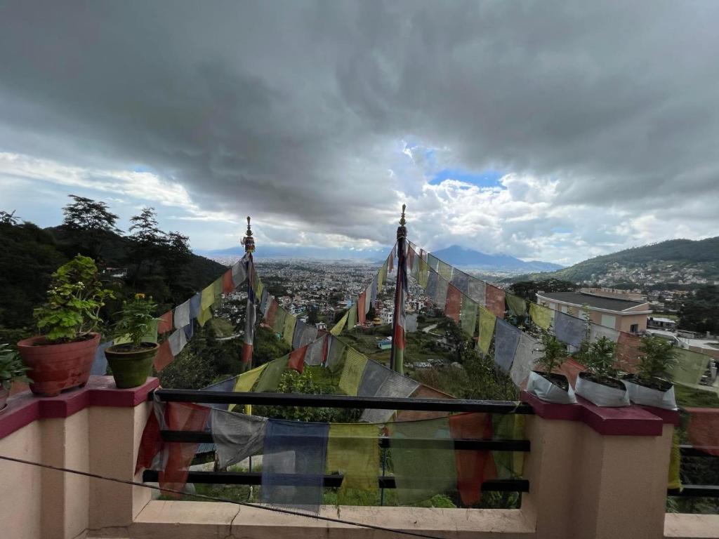 a view of a city from a balcony with prayer flags at Perfect Home Stay in Burhānilkantha
