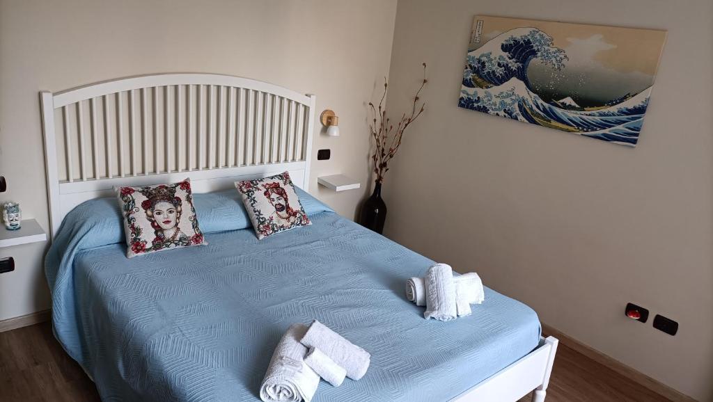 - une chambre avec un lit bleu et des serviettes dans l'établissement Amelia's Home tra Etna e Taormina with pool, à Riposto
