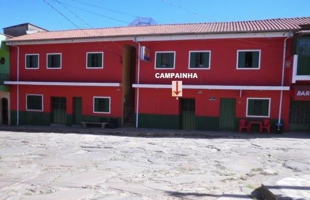 un edificio rojo con un cartel en el costado en Pousada Bela Vista, en São Thomé das Letras