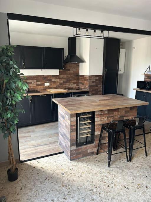 - une cuisine avec un comptoir en bois, une table et des chaises dans l'établissement Appartement spacieux bien situé, à Marseille