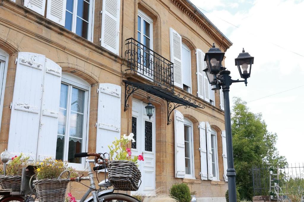 una bicicleta estacionada al lado de un edificio con luz de la calle en Au beau séjour 