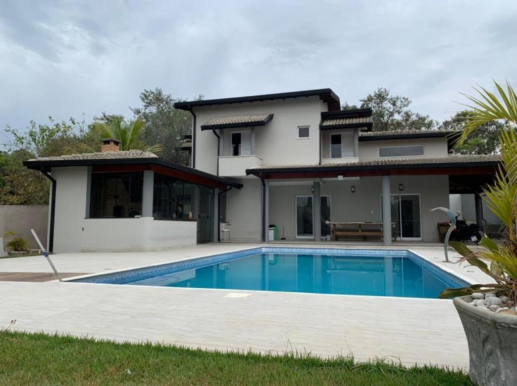 uma villa com piscina em frente a uma casa em Chacara La Bela em Indaiatuba