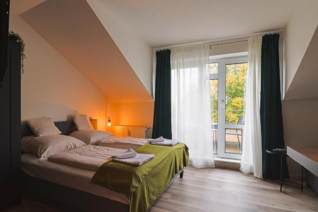 a bedroom with a bed and a large window at K-UNITs: Lübeck Roter Löwe - City Nahes Appartement in Lübeck