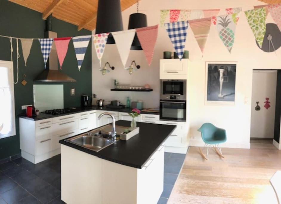eine Küche mit einer Spüle und einer Theke mit Flaggen in der Unterkunft Maison vendéenne à 5 min du bord de mer in Saint-Hilaire-la-Forêt