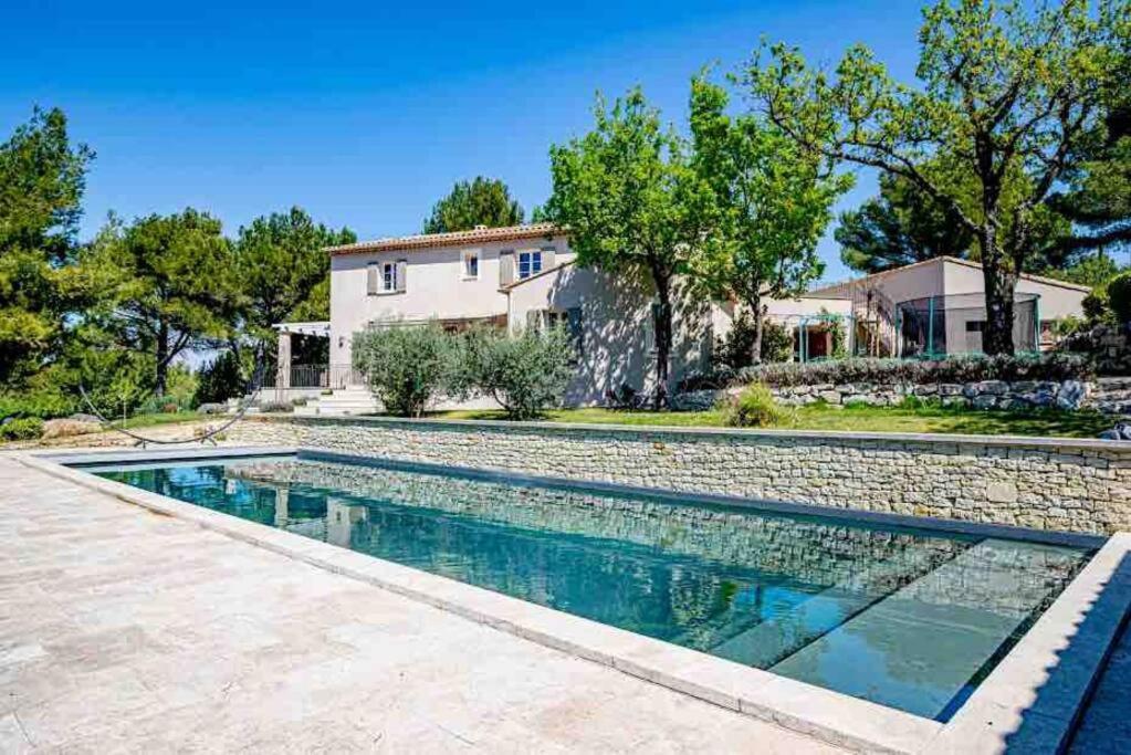 una piscina frente a una casa en Villa des Fontaines luxury family home with pool, en Pernes-les-Fontaines