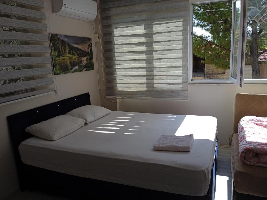Łóżko w małym pokoju z oknem w obiekcie Philips w mieście Pamukkale