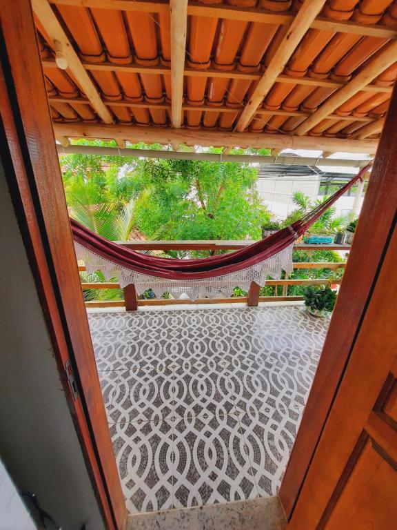 an open door to a porch with a hammock at ITAÚNAS Pousada Nossa Palhoça in Itaúnas