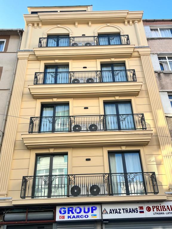 un edificio alto de color amarillo con balcones. en Golden Stone Hotel, en Estambul