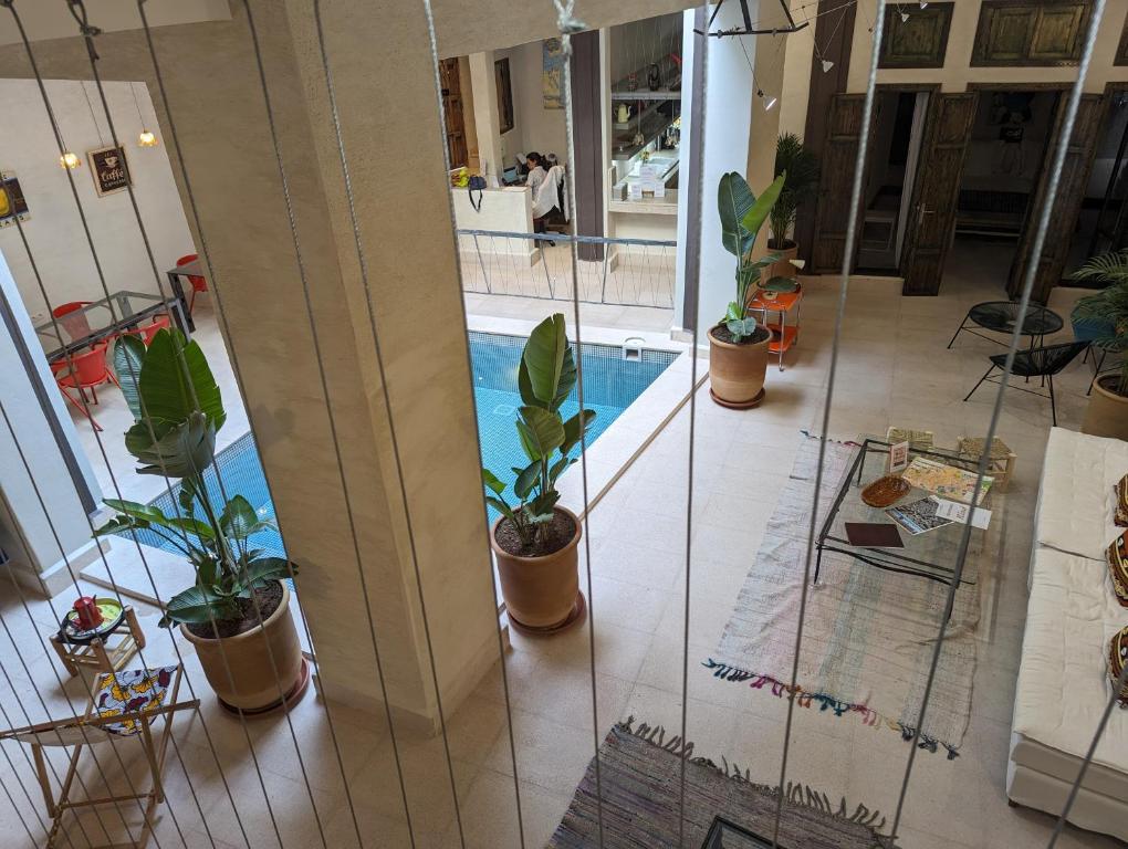 a hallway with potted plants and a swimming pool at Dar d'Art in Marrakech