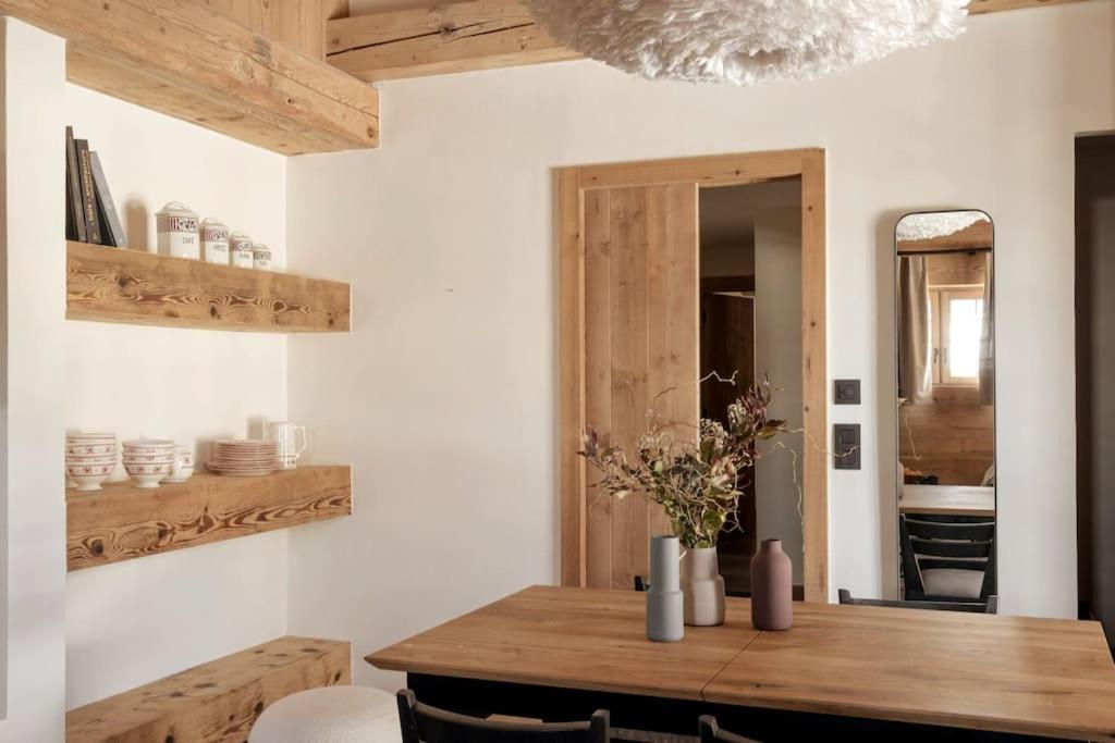 a dining room with a wooden table and a mirror at Appartement Rémy - at the foot of the slopes in Saint-Gervais-les-Bains