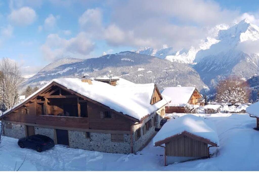 a cabin in the snow with mountains in the background at Appartement Rémy - at the foot of the slopes in Saint-Gervais-les-Bains