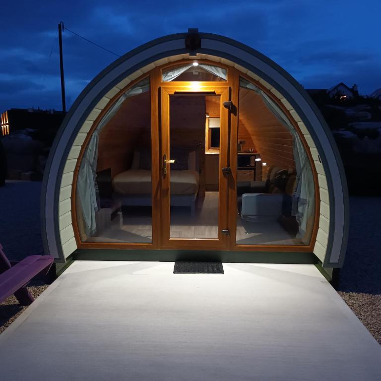 una casa a cupola con una porta a vetri di notte di Wheelhousepods glamping a Donegal