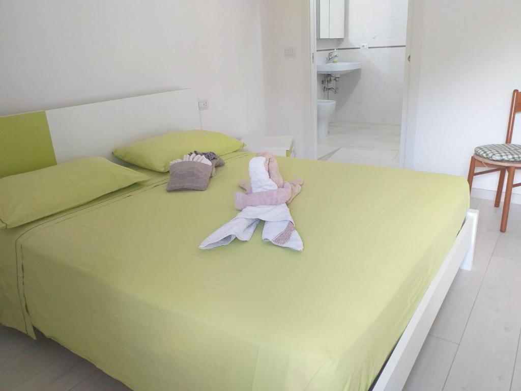 Una gran cama verde con dos animales de peluche. en La casa di Donna Zaira, en Valsinni