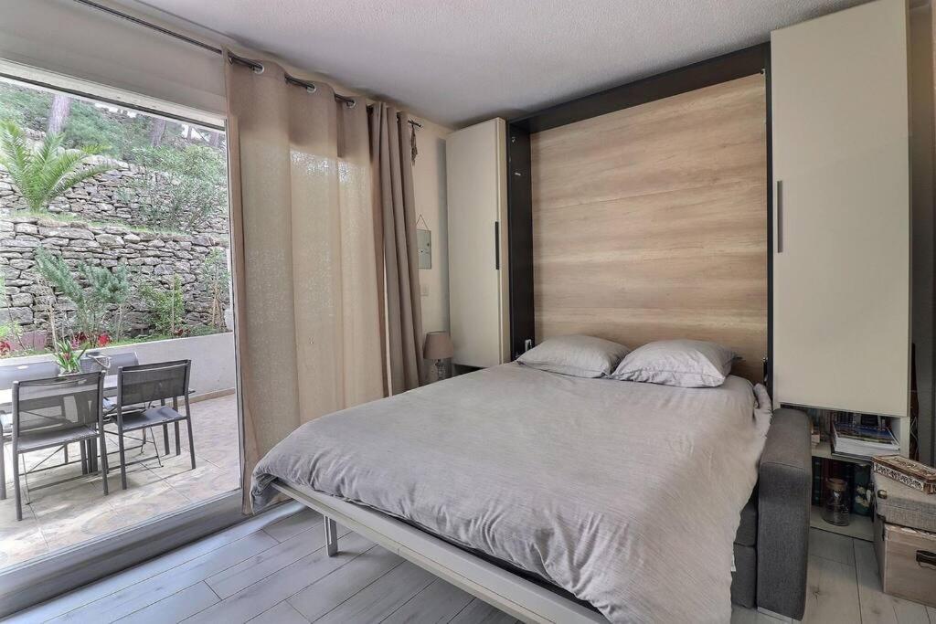 une chambre avec un lit, une table et une fenêtre dans l'établissement Appartement & grande terrasse - proche plage, à La Ciotat