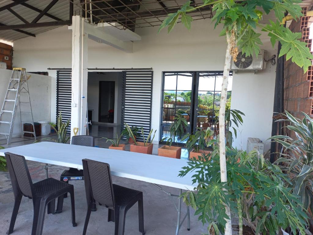 uma mesa branca e cadeiras numa sala com plantas em CasaSpa em La Dorada