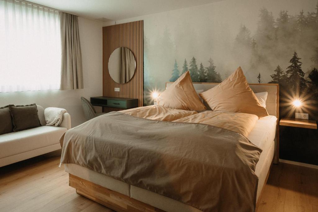 a bedroom with a bed and a couch and a mirror at Boutique Hotel Haus Marie in Gerabronn