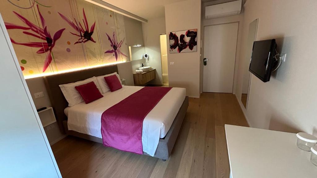 1 dormitorio con 1 cama y una pintura en la pared en SAN LORENZO Luxury Boutique en Mantova