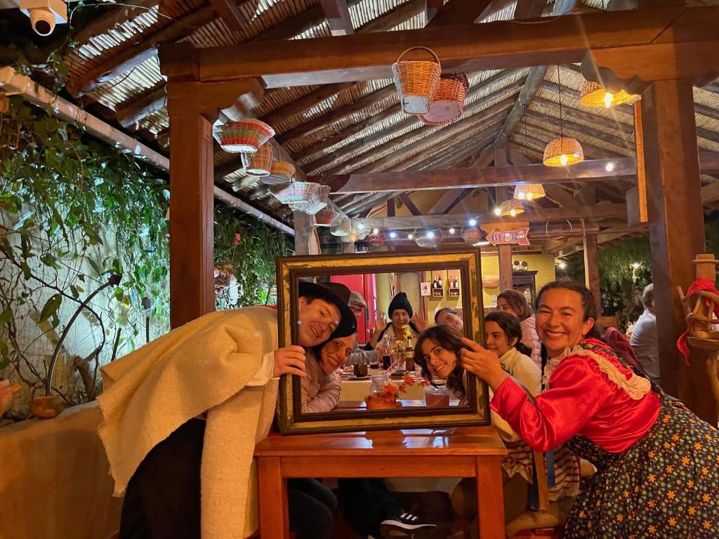 un grupo de personas sentadas en una mesa con un espejo en Voyaca Hotel Alfareria, en Villa de Leyva