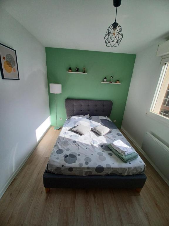 une chambre avec un lit et un mur végétal dans l'établissement Appartement 2 personnes Lyon Sans Souci, à Lyon