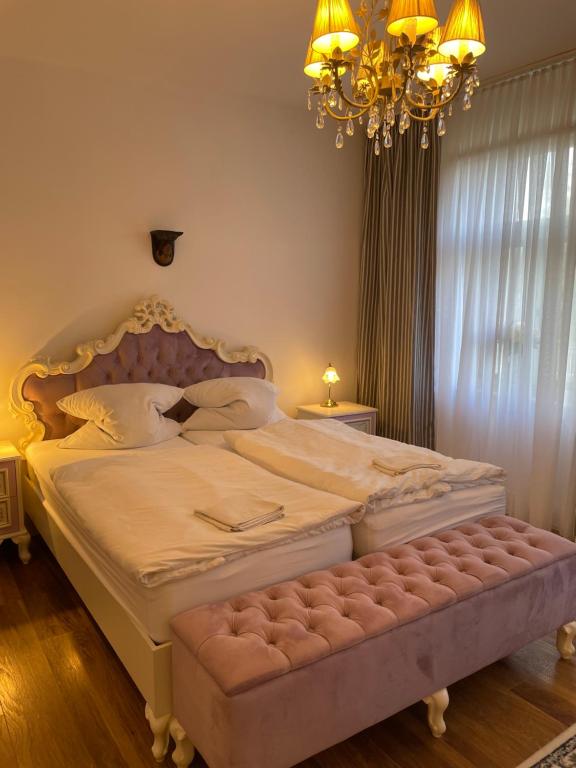 1 dormitorio con 1 cama grande y lámpara de araña en Pension zum Landhaus, 