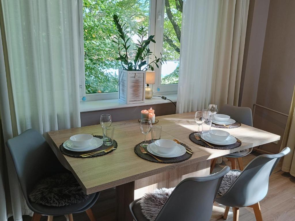 een eettafel met stoelen en een raam bij Apartment Rybaki in Gdańsk