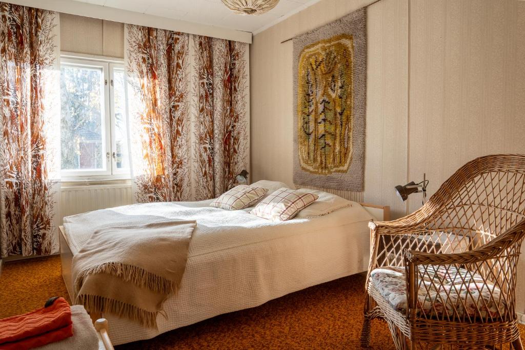 1 dormitorio con 1 cama, 1 silla y 1 ventana en Grandma Tyyne's home, en Rovaniemi
