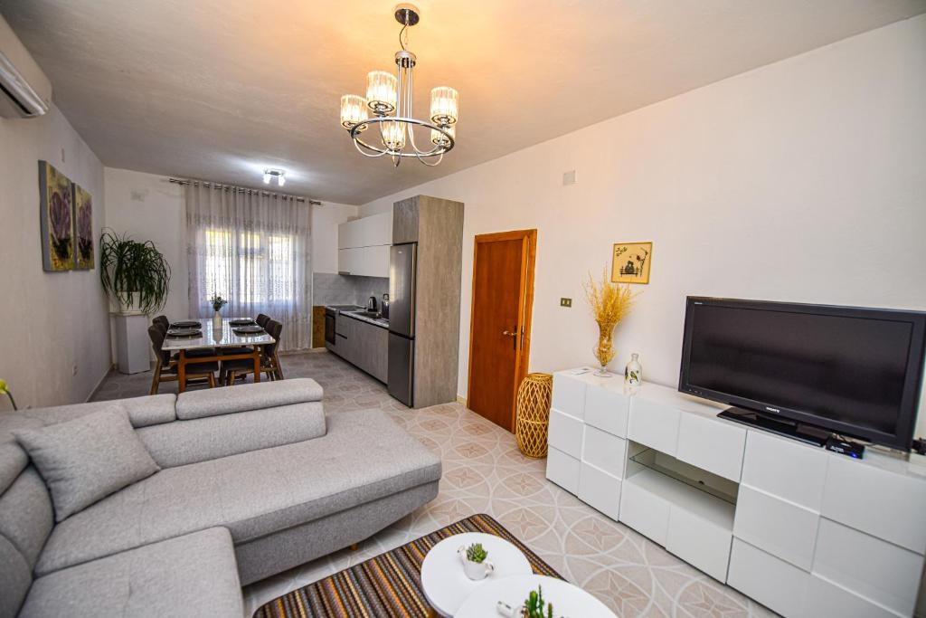 a living room with a couch and a flat screen tv at Villa Alba in Shkodër