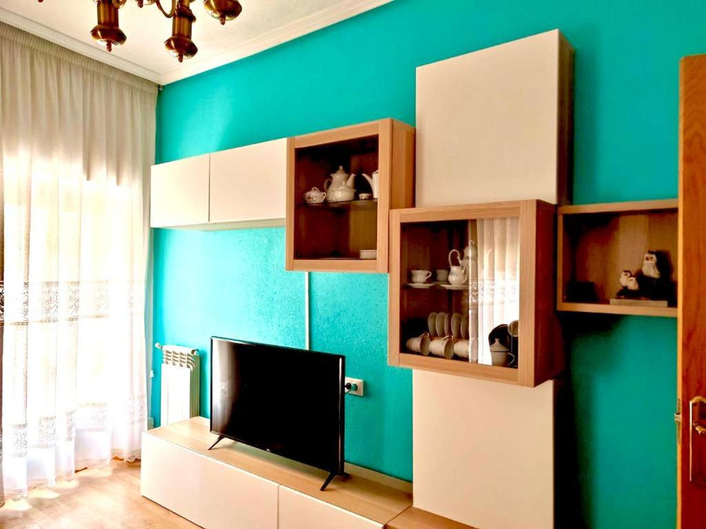 uma sala de estar com televisão e uma parede verde em Libertad, 1 em Zamora