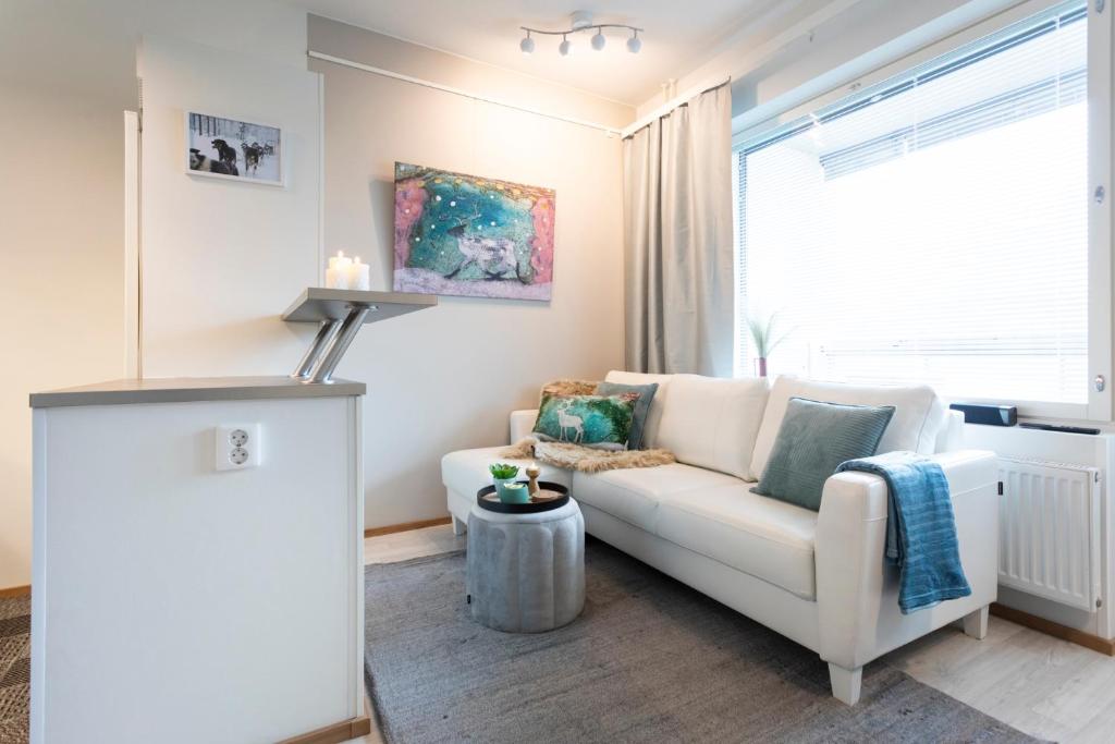 un soggiorno con divano bianco e finestra di Vasko luxurious suites, Soilu a Rovaniemi