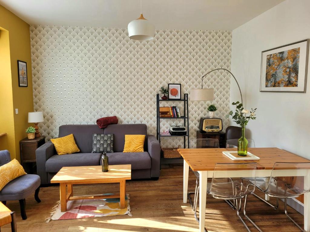 una sala de estar con un sofá y una mesa en Gîte Homard - Bord de mer - 4/6 personnes, en Quinéville