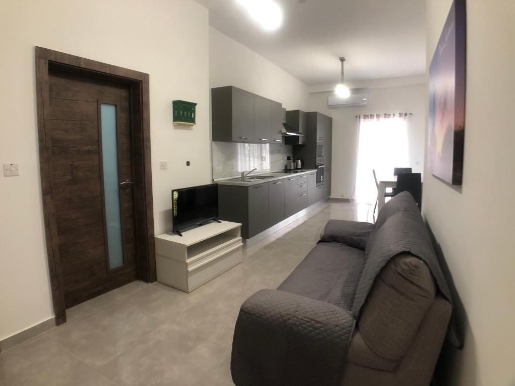 sala de estar con sofá y cocina en Central Apartment Close to Uni, Sliema & Mater Dei, en Il-Gżira