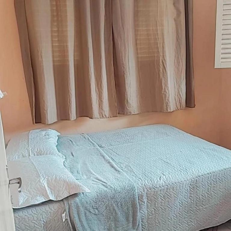 uma cama num quarto com uma janela em Casa Santa Ana, Bananeiras PB em Bananeiras