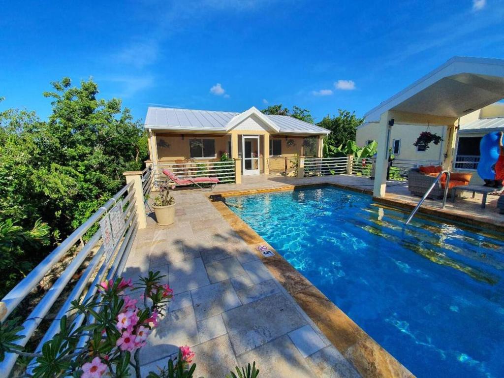 a house with a swimming pool in front of a house at Just Chillin in Little Cayman in Head of Bay