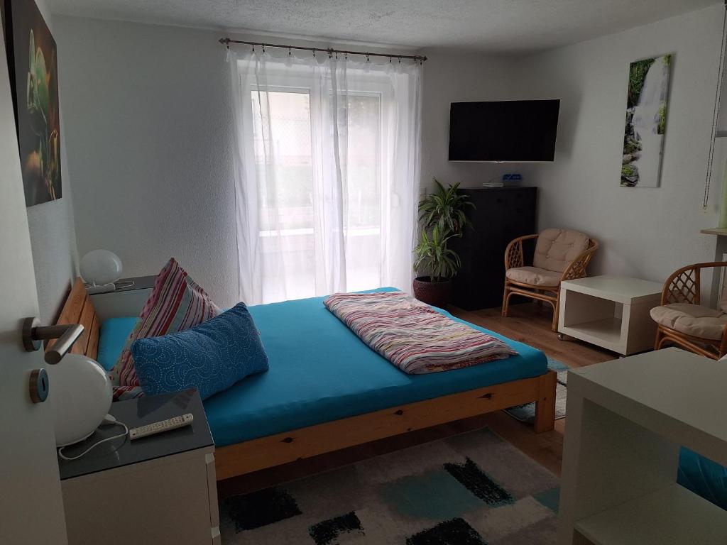 een slaapkamer met een bed met een blauwe matras bij Schöni´s Zimmer in Abstatt