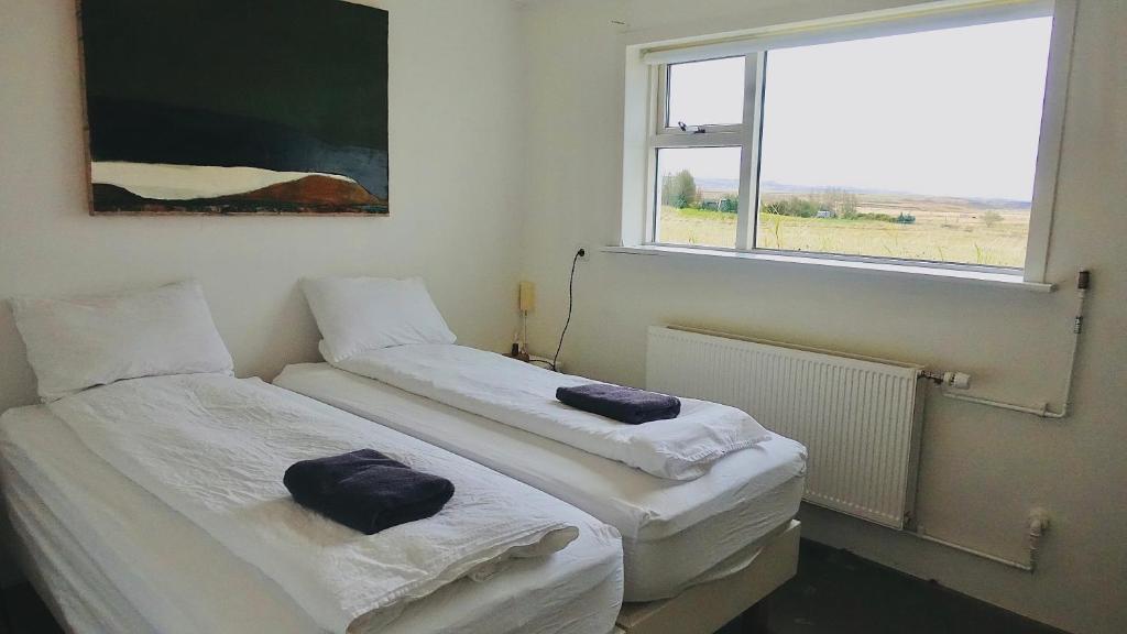 two twin beds in a room with a window at Mengi Countryside in Kjarnholt