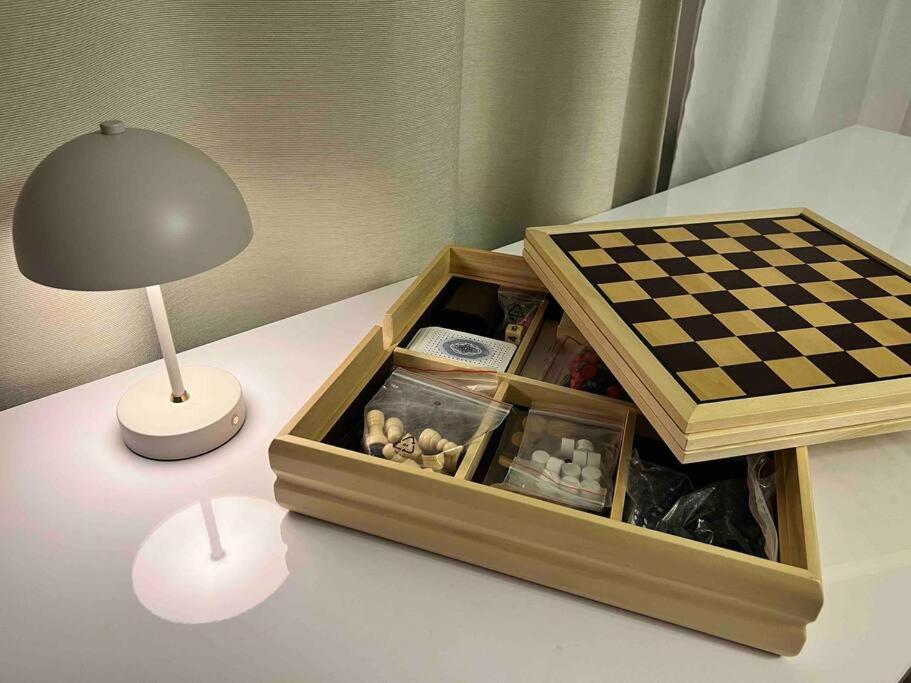 a lamp and a chess board on a table next to a lamp at Luxury Pearl with Parking place in Holešovice in Prague