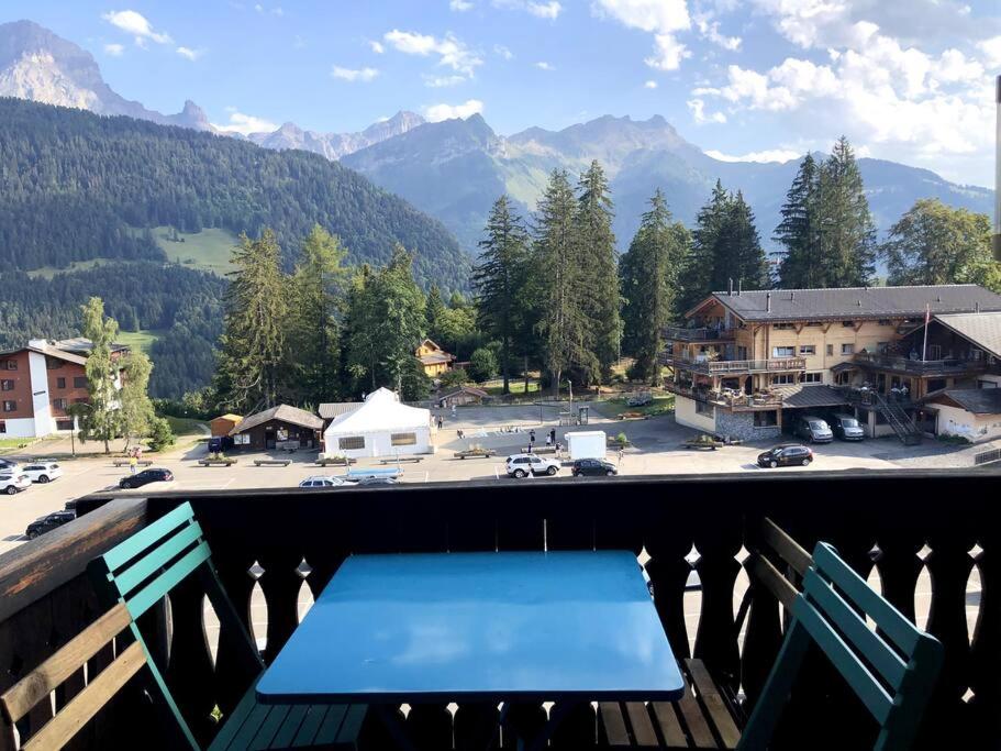 una panchina blu su un balcone con vista su un parcheggio di Charmant studio idéalement situé a Gryon