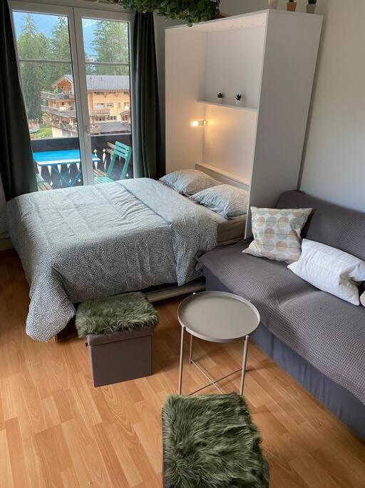 una camera da letto con un letto, un divano e un tavolo di Charmant studio idéalement situé a Gryon