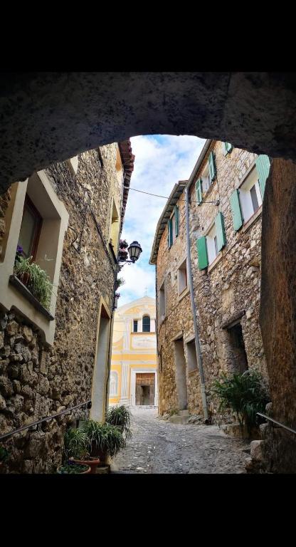 - une vue sur une ruelle située entre deux bâtiments en pierre dans l'établissement Charmant appartement de village rénové, à Gorbio