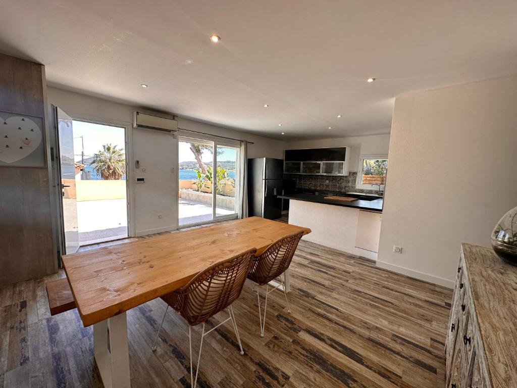 une cuisine avec une table en bois et une grande fenêtre dans l'établissement Maison provençale au bord de l’eau, à Istres
