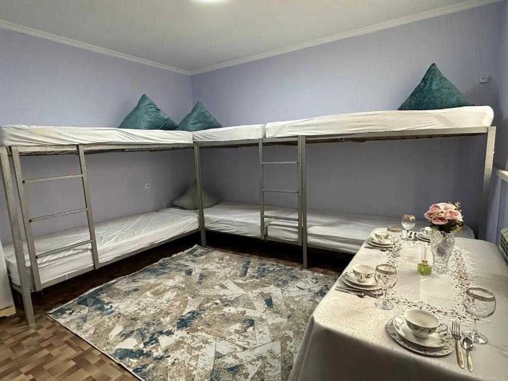 a room with two bunk beds and a table at Joy in Atyrau