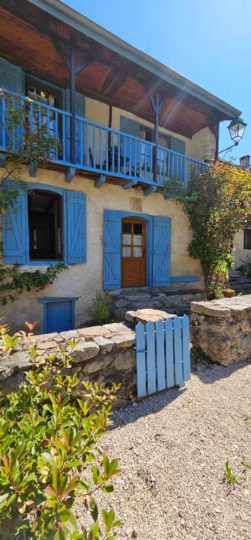 Casa con puertas azules y balcón. en Bergerie Ariégeoise, en Ustou