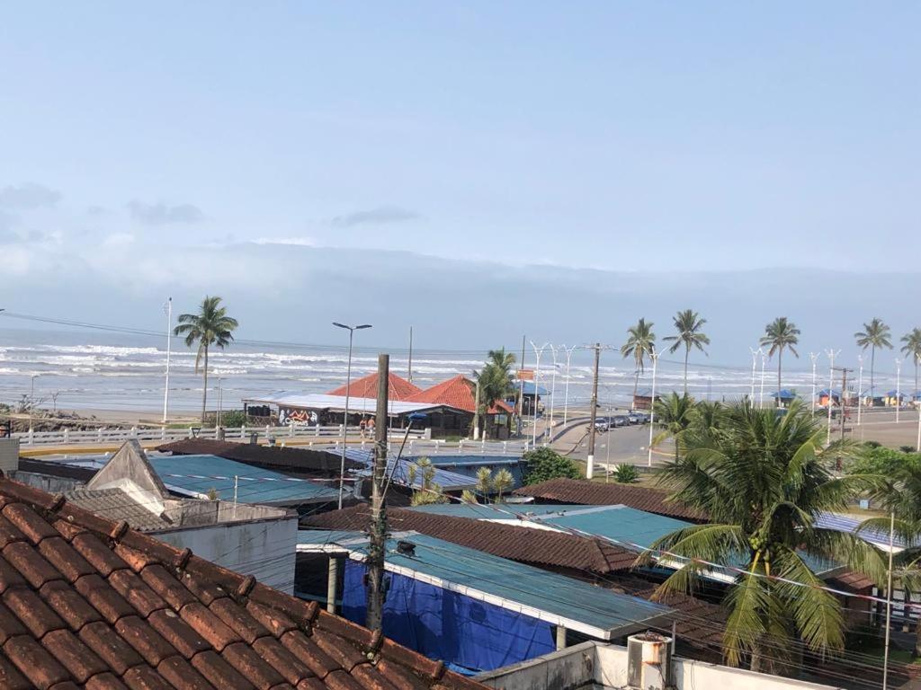 uma vista para uma praia com palmeiras e edifícios em Kitnet Cantinho 26 em Mongaguá