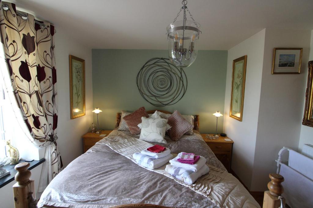 sypialnia z łóżkiem z ręcznikami w obiekcie Melorne Farm Guest House w mieście Camelford